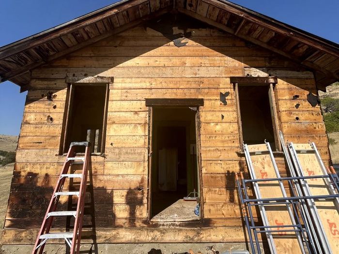After: the same cabin with the old shingles removed down to the wood