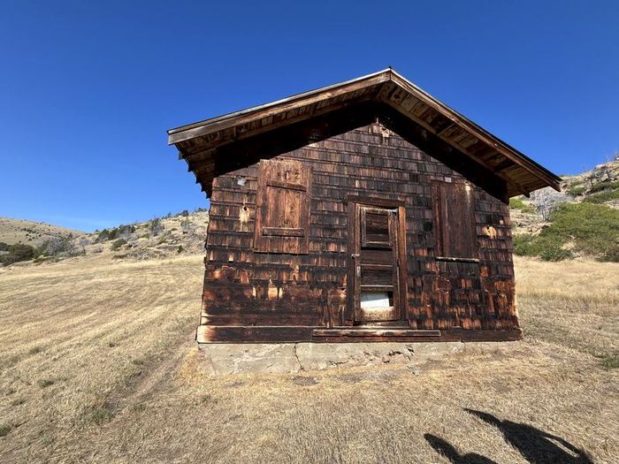 Before: historic ranch cabin covered in weathered shingles