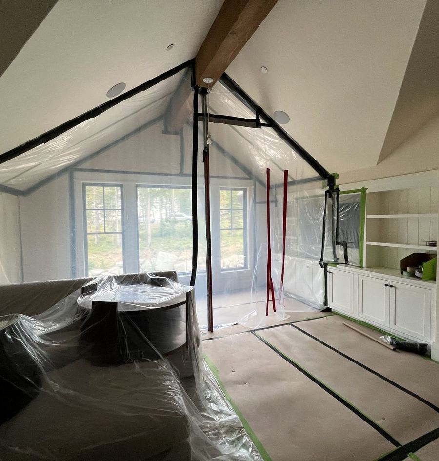 Living room sealed in plastic containment with floors and built-ins protected