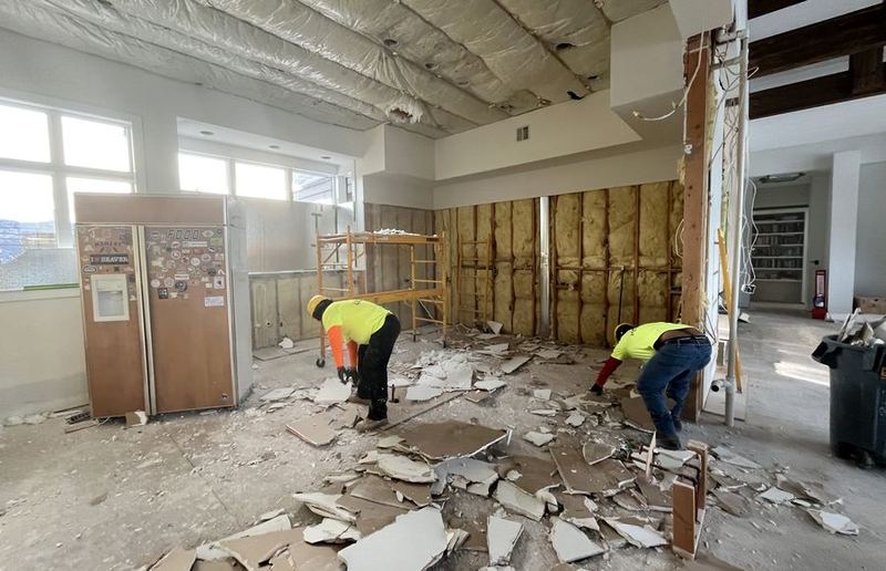 Local Demo crew tearing out drywall and insulation during an interior renovation
