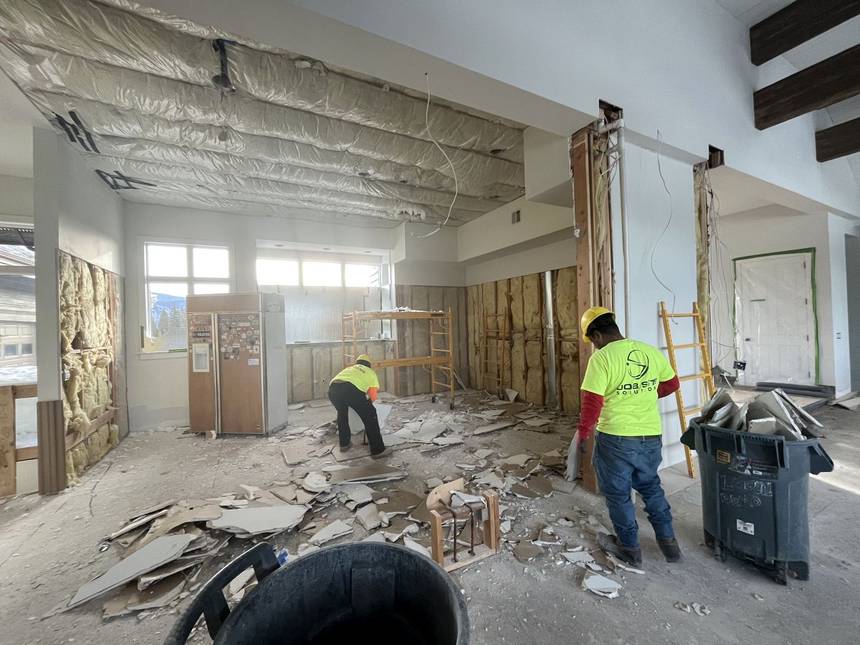 Crew in hi-vis tearing out ceiling and wall materials during the Miller renovation Crew in hi-vis tearing out ceiling and wall materials during the Miller renovation