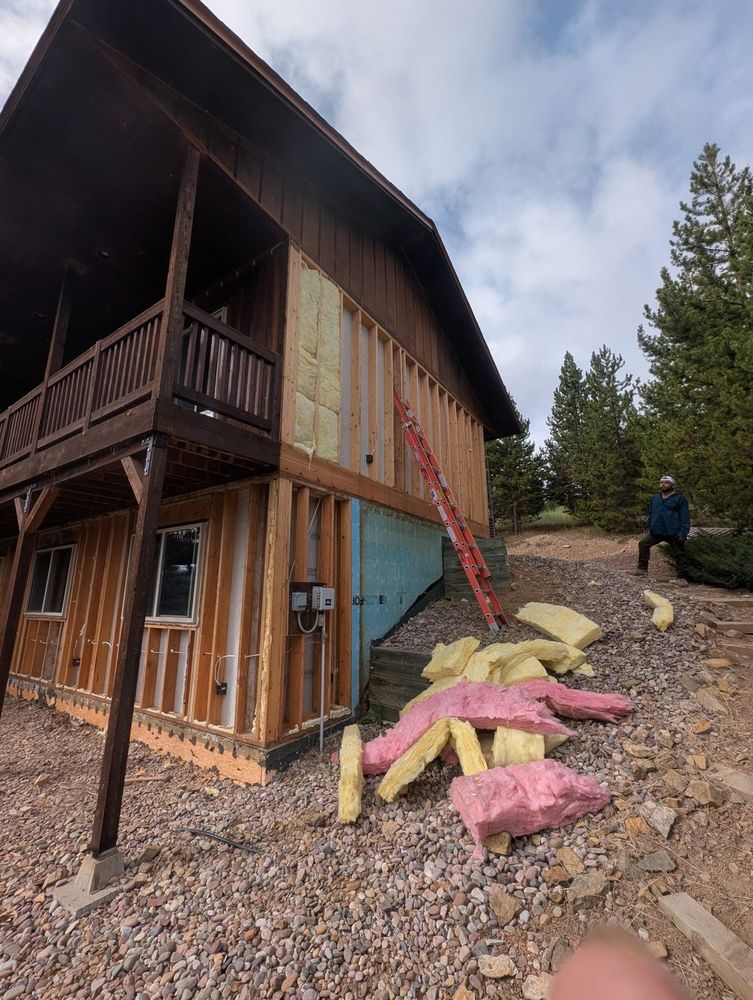 Two-story home with siding and insulation removed and the framing and decks left standing
