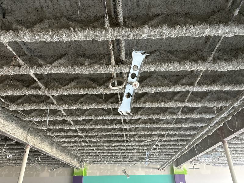 Ceiling deck with sprayed-on insulation before abatement