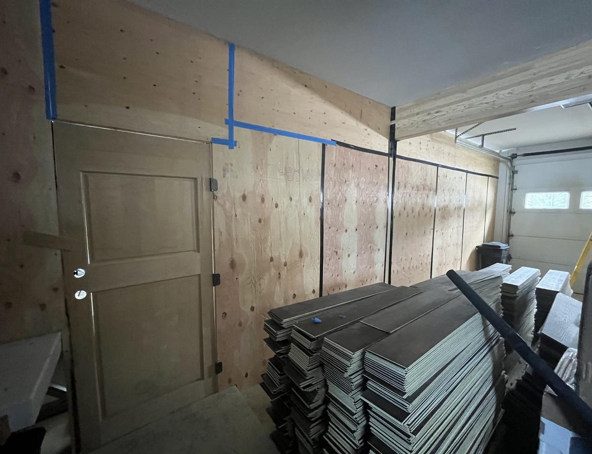Temporary plywood barrier wall sealed with tape to contain a work zone Temporary plywood barrier wall sealed with tape to contain a work zone