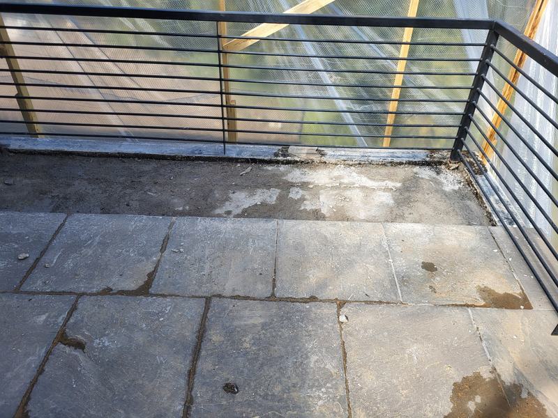 Deck and railing wrapped in plastic sheeting before tile removal