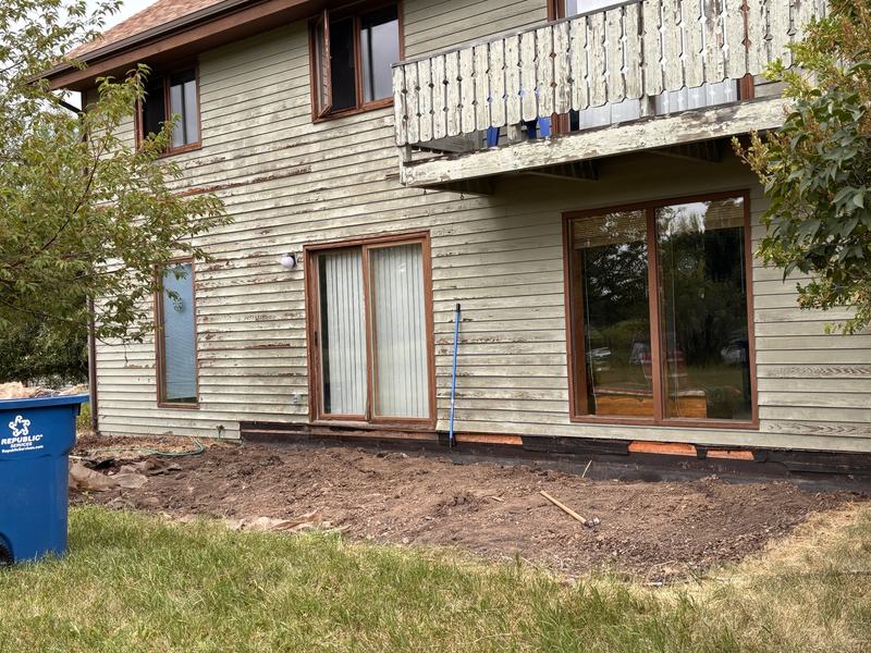 Older two-story home with weathered painted siding and trim
